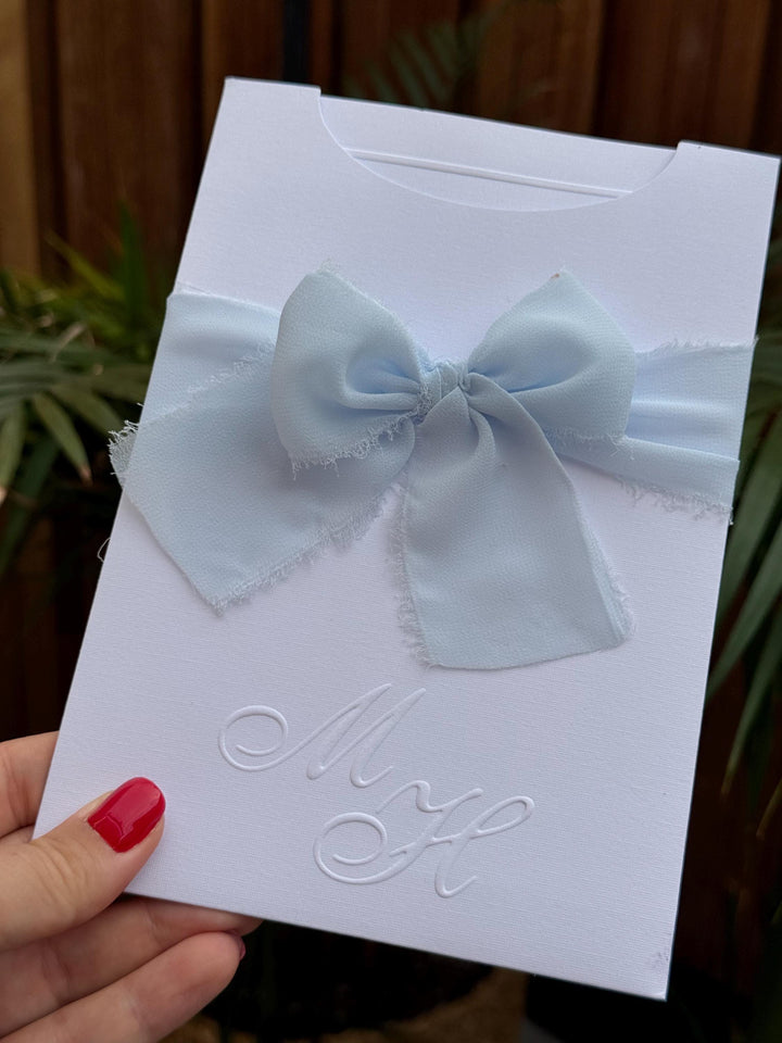 White Wedding Invitation With Blue Ribbon and Embossed Text